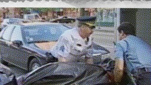 newspaper image of paramedics carrying covered dead body