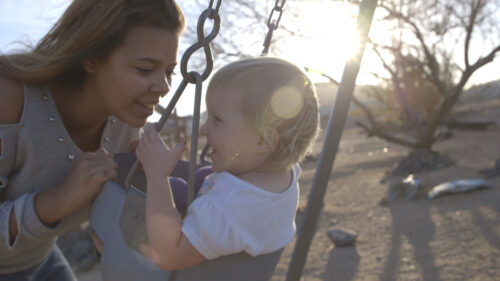 mother and baby on park swing 