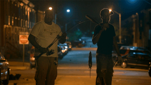 two men outside at night with fishing pole and baseball bat