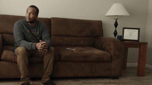 man sitting on sofa