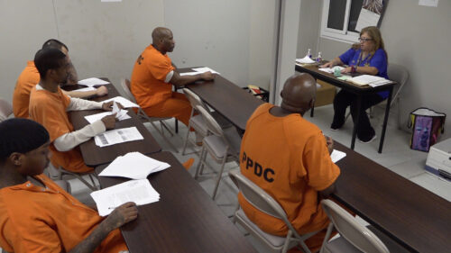 men in prison inside a classroom