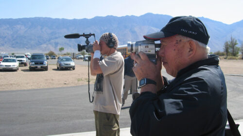 filmmaker Robert A. Nakamura using a camcorder in the desert