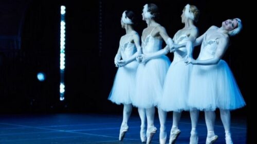 Four ballerina boys performing Swan Lake on stage