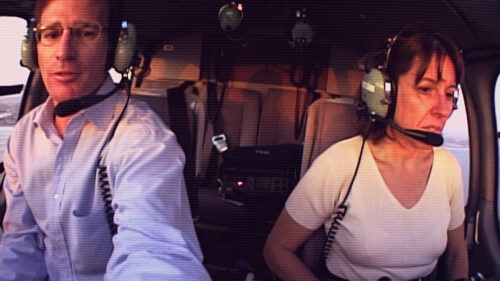 man and woman flying helicopter 