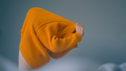 Stylized photo of someone taking off a sweater
