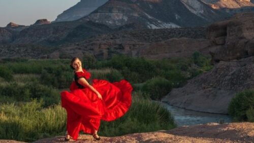 woman in the desert wearing red folklorico dress