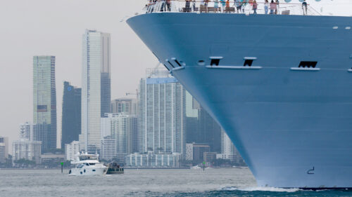 large cruise ship front with city in backgound