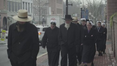 Amish men and women approaching a courthouse to attend a court hearing for an Amish sexual offender
