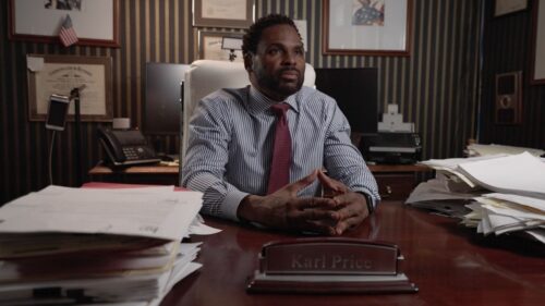 Lawyer looking serious sitting at desk with lots of clutter 