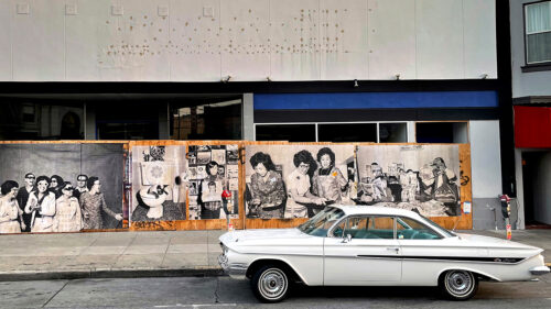 Art on street wall with car infront