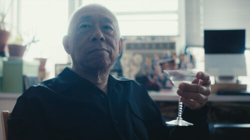 Bald man holding martini glass