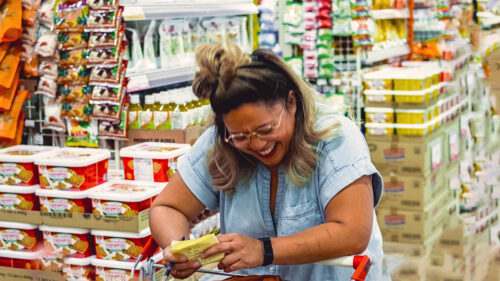 woman in supermarket laughing 