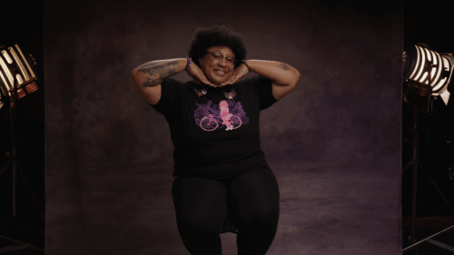 Woman sitting on film set smiling and posing for the camera while sitting
