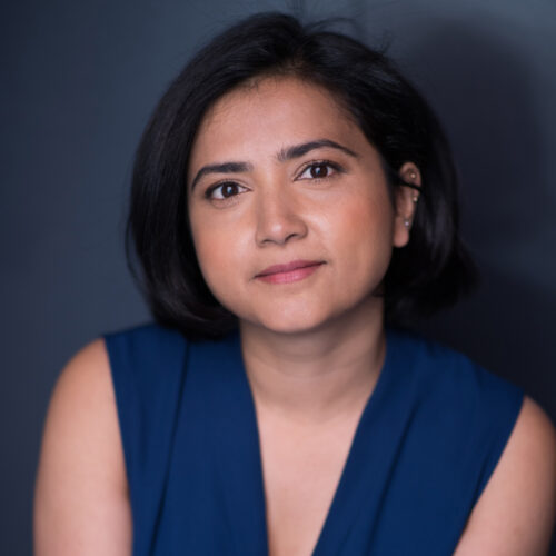 Headshot of woman with dark hair cut above shoulder, dark eyes and medium dark skin tone