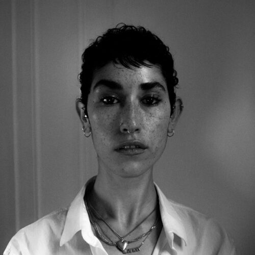 Headshot of person with dark short brown hair and lighter skin tone and dark eyes